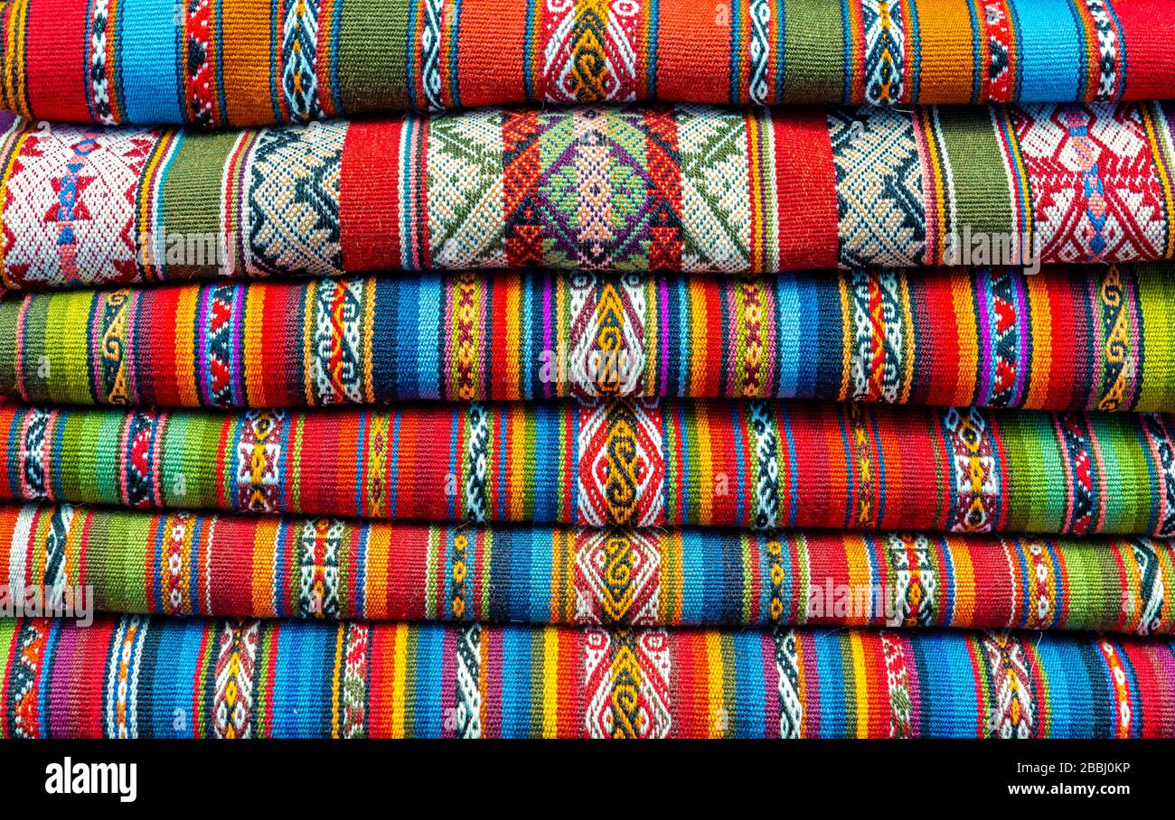 Une pile de tissus andins colorés sur le marché local de Chinchero, province de Cusco, Pérou. Banque D'Images