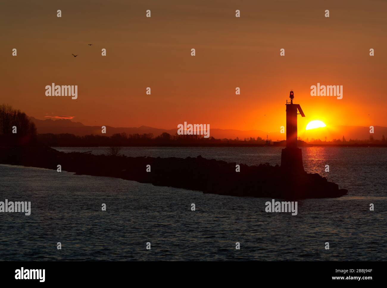 Lever du soleil Fraser River Richmond BC. Lever du soleil derrière une aide à la navigation sur le fleuve Fraser. Vancouver (Colombie-Britannique), Canada. Banque D'Images