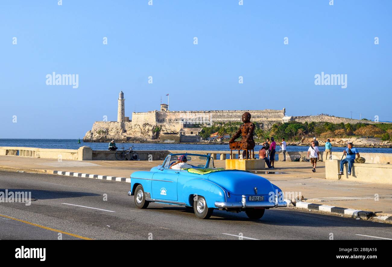 Voiture classique sur Malecon et El Castillo de los Tres Reyes Magos del Morro ou simplement « El Morro » au loin, la Havane Vieja, Cuba Banque D'Images