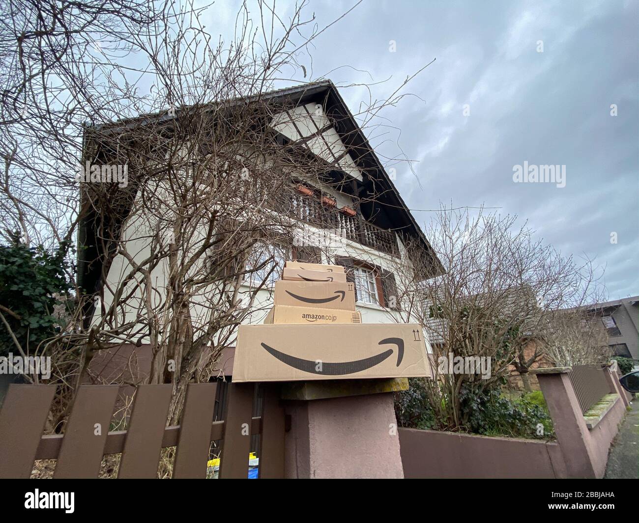 Strasbourg, France - 26 février 2020: Vue à bas angle de plusieurs piles de  colis de carton Amazon Prime sur la clôture en pierre de la maison  alsacienne moderne typique en arrière-plan