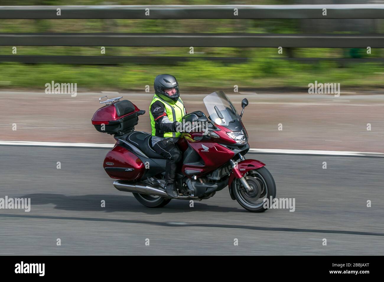 Moto Honda NT700 V Deauville en voiture sur l'autoroute   près de Preston dans Lancashire, Royaume-Uni Banque D'Images