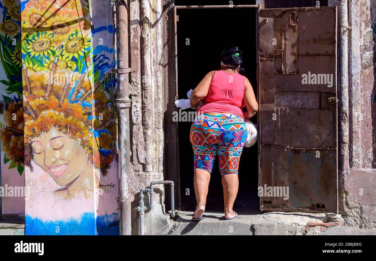 Street art et femme entrant dans la porte, la Havane Vieja, Cuba Banque D'Images