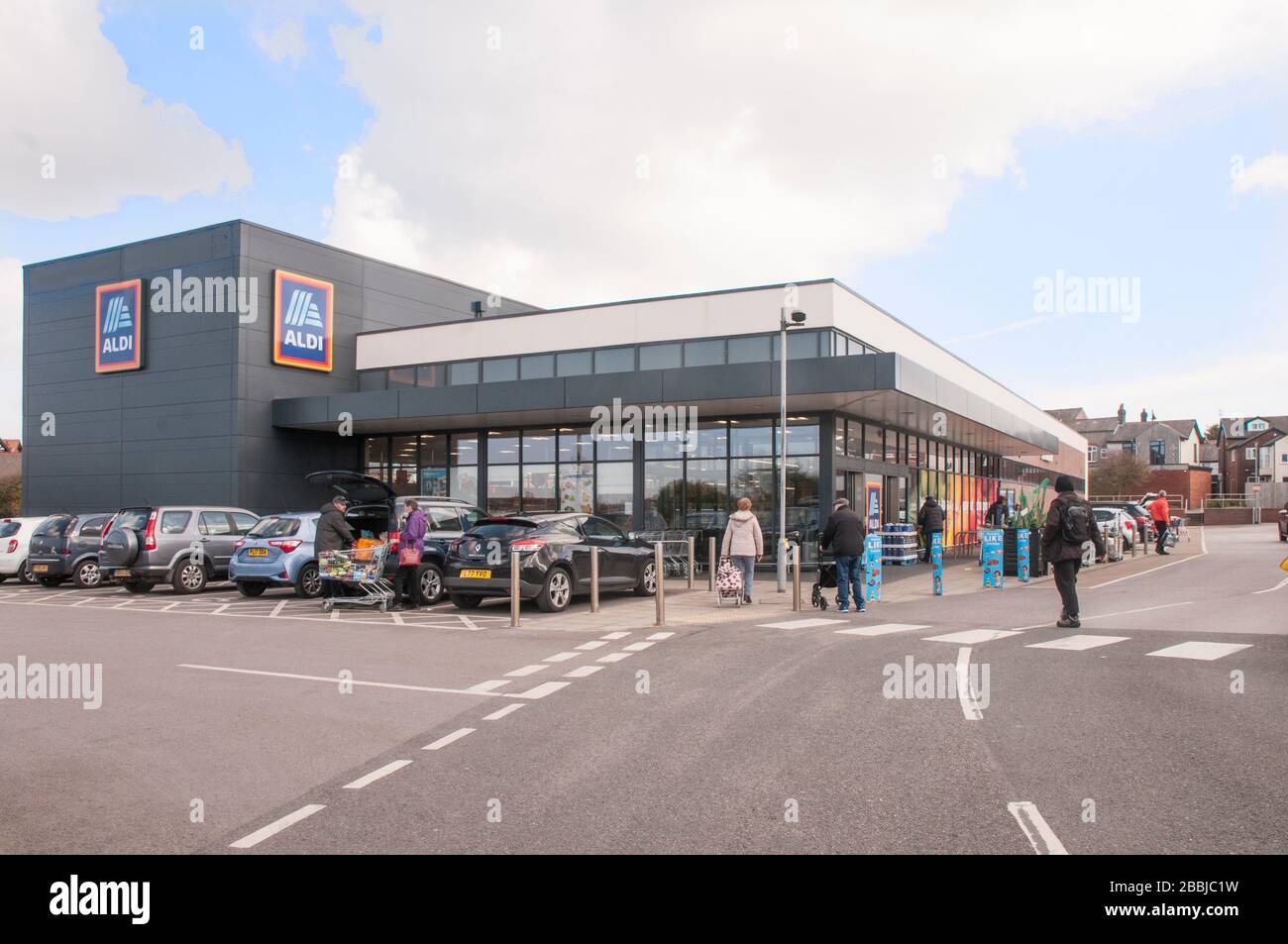 Les clients qui vont dans un magasin Aldi récemment construit à Poulton le Fylde Lancashire Angleterre Royaume-Uni vendent des articles de réduction des coûts tels que des boissons, de la nourriture, des vêtements, etc Banque D'Images