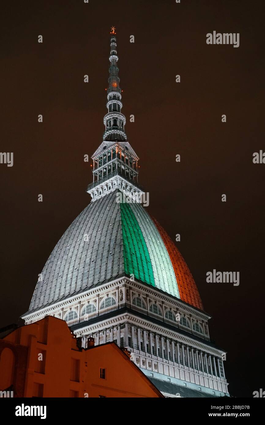 Le Mole Antonelliana est illuminé avec le drapeau italien pour se souvenir des nombreuses victimes de la pandémie de coronavirus. TURIN, ITALIE - MARS 2020 Banque D'Images