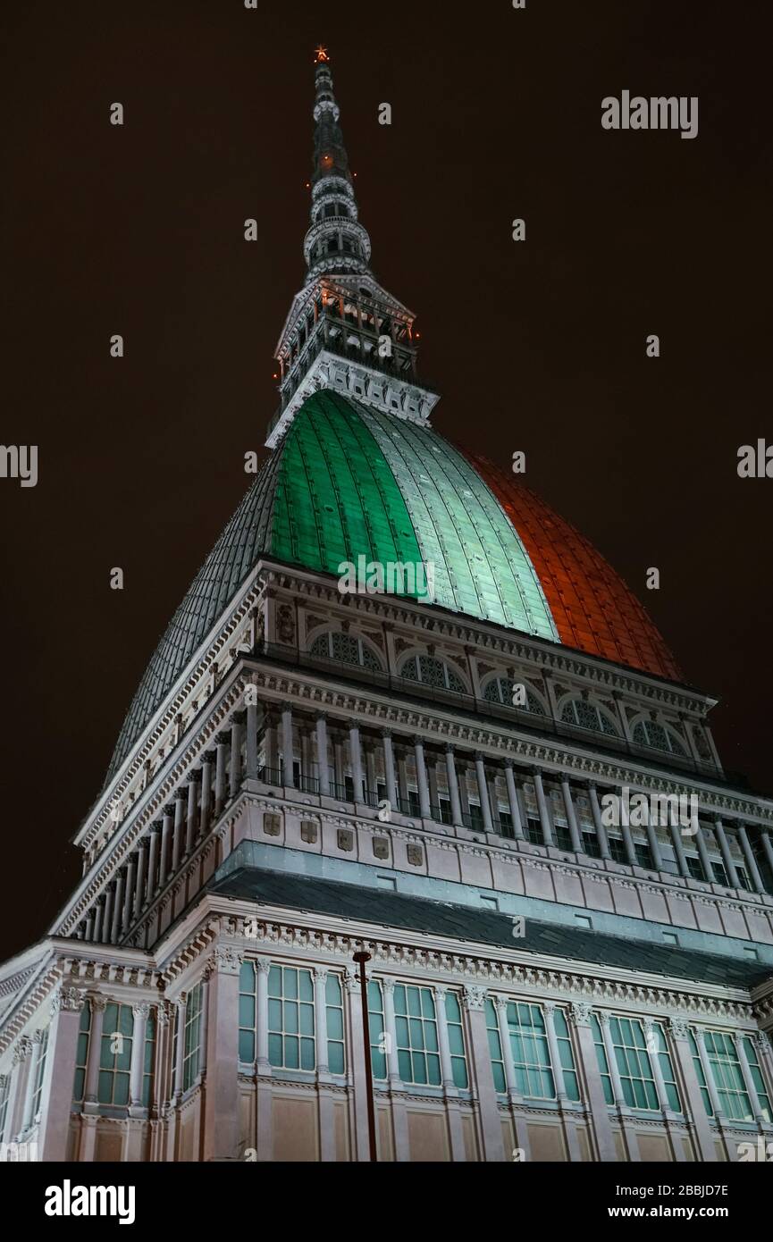 Le Mole Antonelliana est illuminé avec le drapeau italien pour se souvenir des nombreuses victimes de la pandémie de coronavirus. TURIN, ITALIE - MARS 2020 Banque D'Images