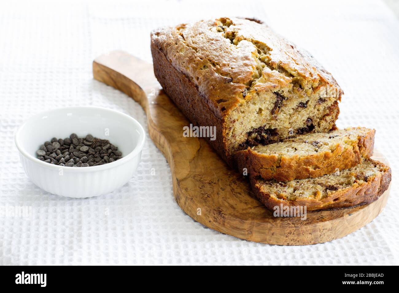 Pain au chocolat et à la banane sur une planche à découper en bois Banque D'Images