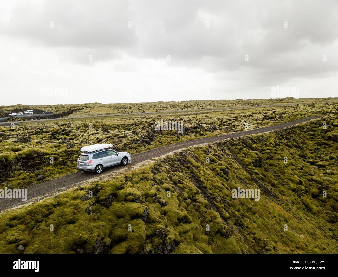 Vue aérienne de la voiture traversant des roches de lave couvertes de mousse dans l'IC Banque D'Images