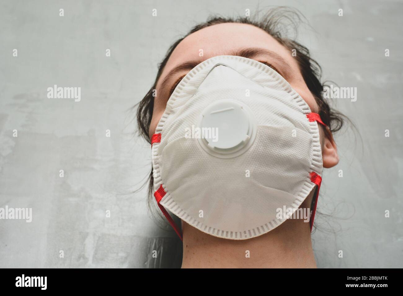 Jeune femme portant un masque de protection ou un respirateur. Bannière avec anti-coronavirus, virus et concept de grippe. Banque D'Images