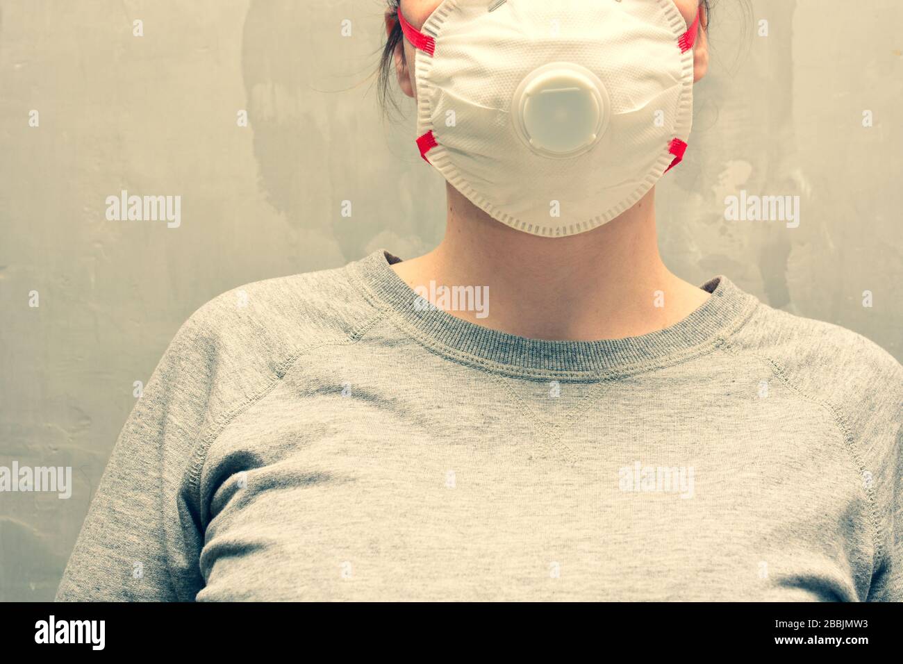 Jeune femme portant un masque de protection ou un respirateur. Bannière avec anti-coronavirus, virus et concept de grippe. Banque D'Images