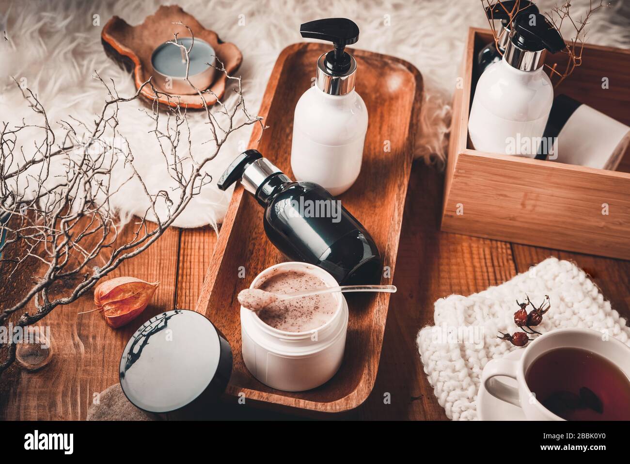 Bouteilles cosmétiques avec cosmétiques pour le soin du corps sur une table en bois. Le spa est situé sur un fond en bois. Banque D'Images