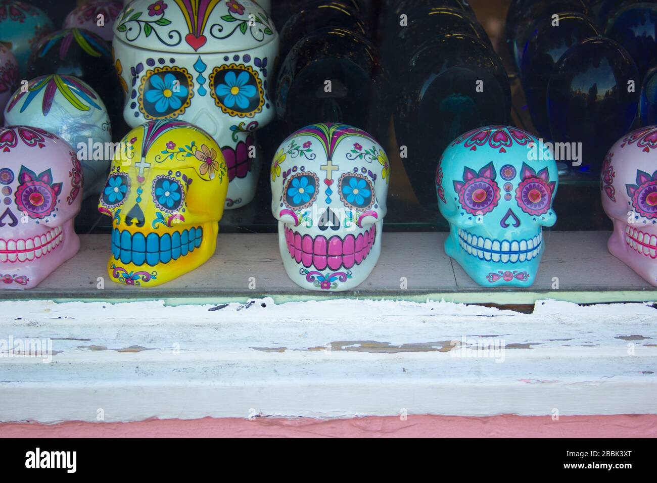 Une rangée de crânes de sucre colorés à vendre dans une vitrine de magasin Banque D'Images