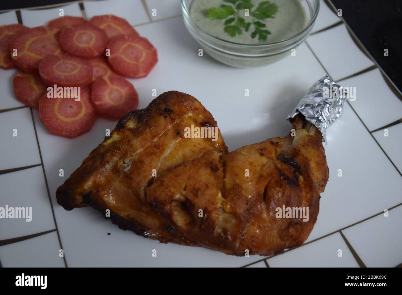 Tikka de poulet cuit maison avec carottes fraîches et sauce à la menthe Banque D'Images