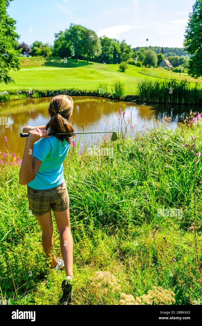 jeune golfeur féminin faisant une oscillation parfaite de golf de profondeur rugueuse Banque D'Images