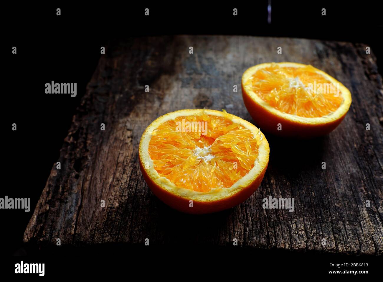 Gros plan de la vue élevée des fruits jaunes d'orange couper deux dans la moitié, fraîcheur des fruits crus d'agrumes, riche vitamine C, bon pour la santé sur fond de bois Banque D'Images
