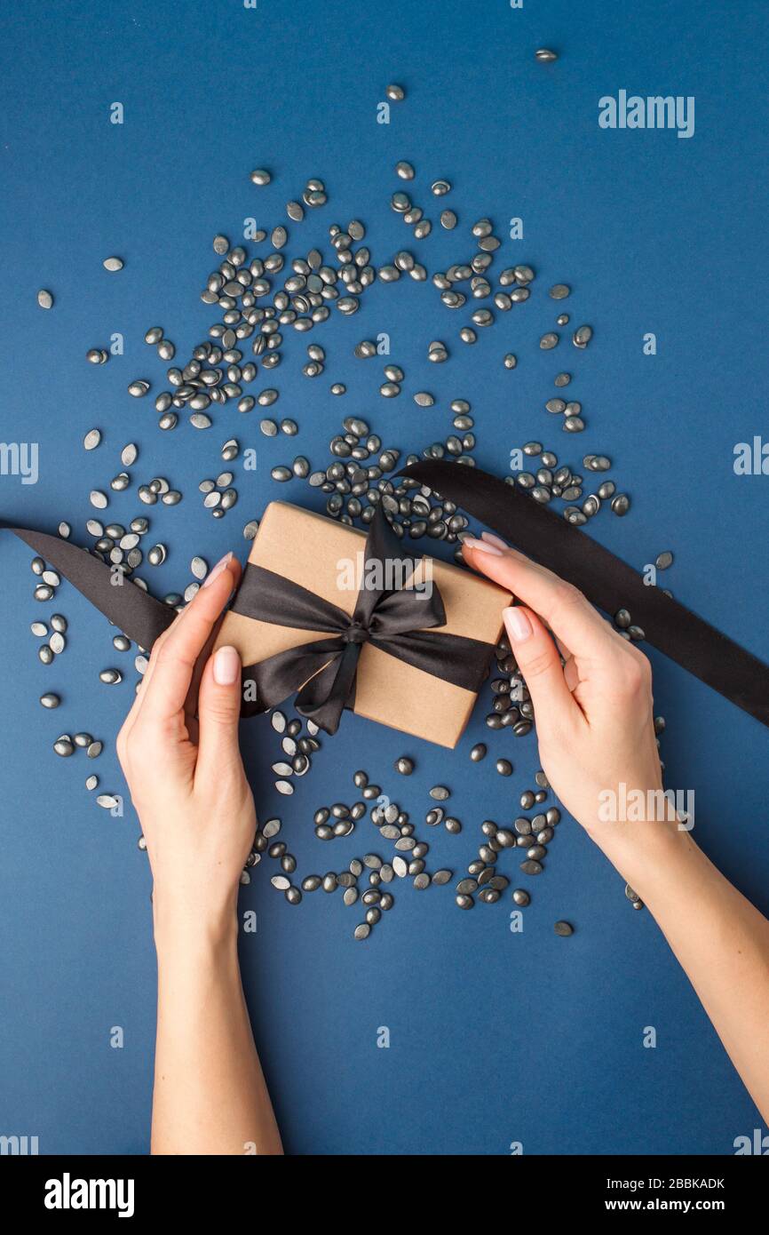 Cire à grains de perle noire pour l'épilation et la femme sur fond bleu avec boîte cadeau. Espace de copie, bannière, prospectus, coupon. Le concept de promouvoir depila Banque D'Images