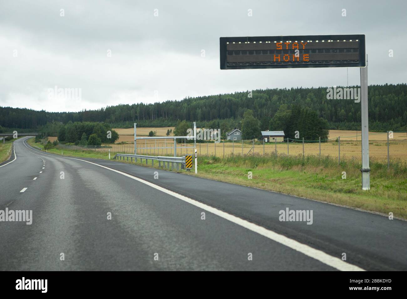 Autoroute avec panneau d'information. Légende « tay at home ». Interdiction de mouvement en quarantaine Banque D'Images