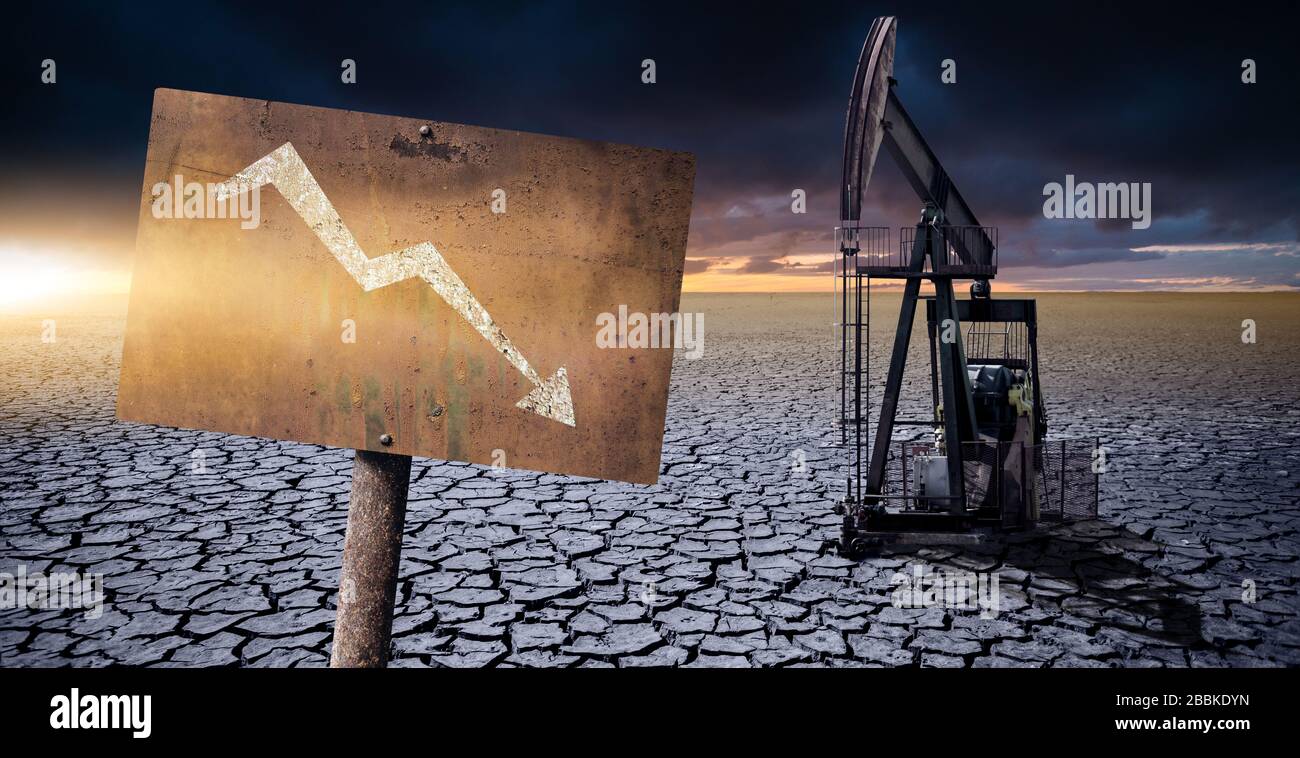 Rig de pétrole dans le désert sur un fond de ciel dramatique. Signe rouillé avec flèche vers le bas. Symbole de l'effondrement de l'industrie pétrolière Banque D'Images