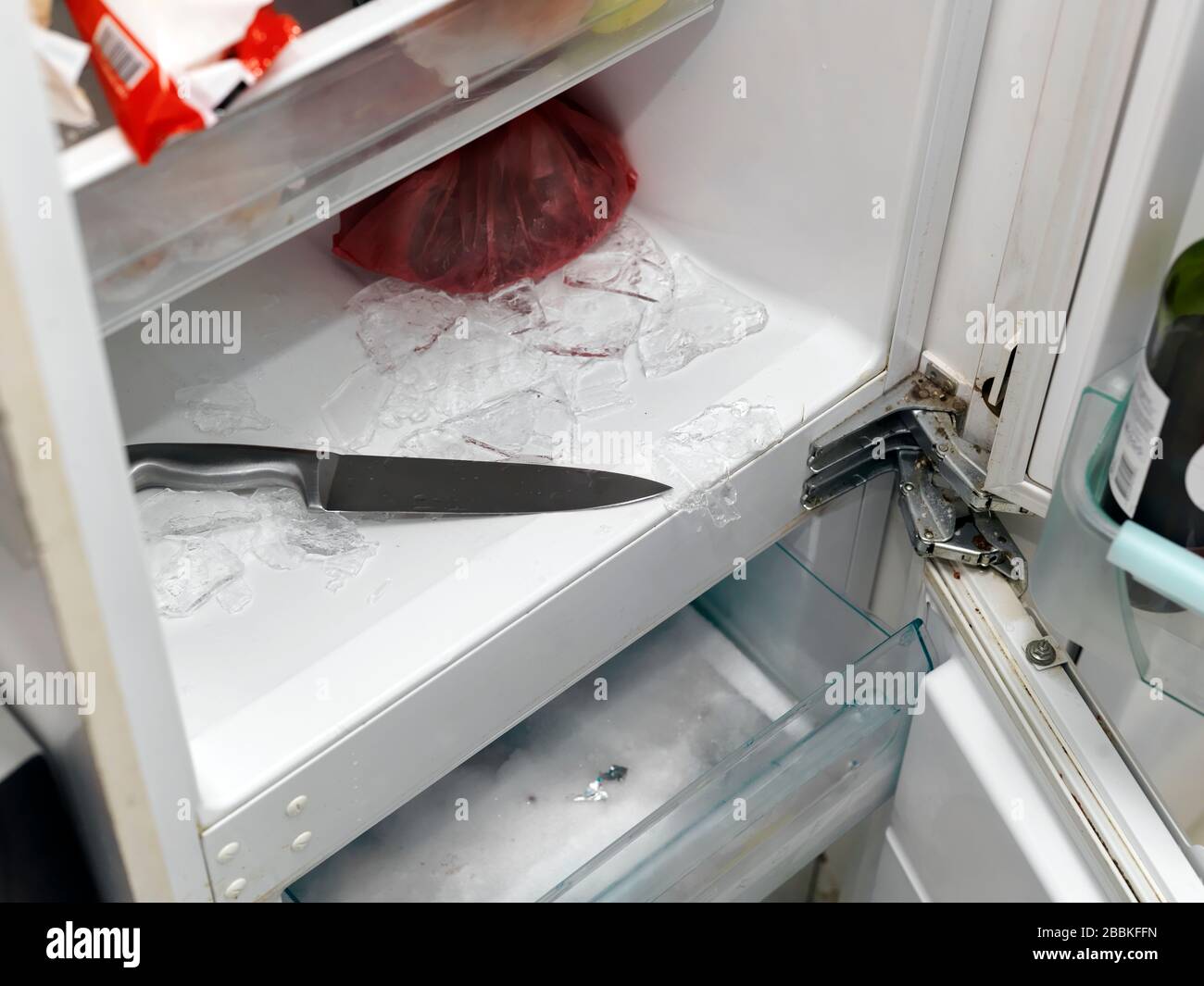 Retirer la glace d'un congélateur avec couteau de cuisine, fermeture  intérieure Photo Stock - Alamy