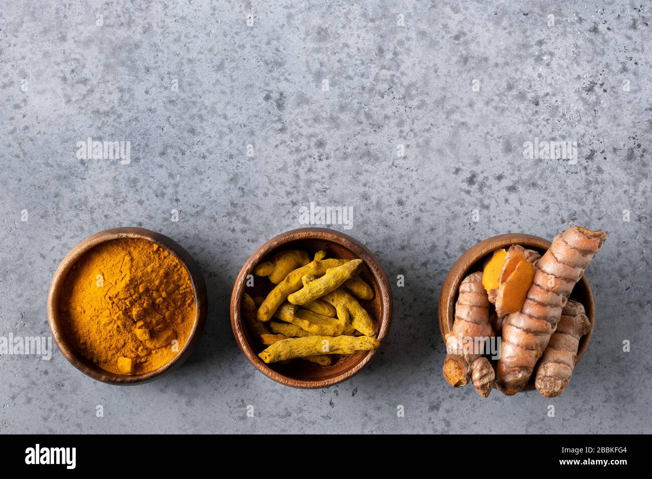 Curcuma, curcuma, curcuma, curcuma, frais et sec, dans un bol sur une table en pierre grise. Espace pour le texte. Bonne immunité aux épices. Vue de dessus. Antiseptique naturel. Banque D'Images