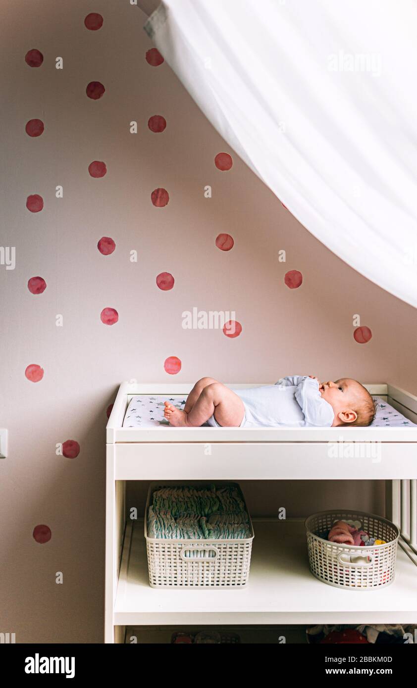 Le Petit Bebe Est Allonge Sur La Table Des Enfants Pres De La Fenetre Il Y A Un Enfant De Nouveau Ne Sur La Table De Changement De Bebe Photo Verticale Photo Stock
