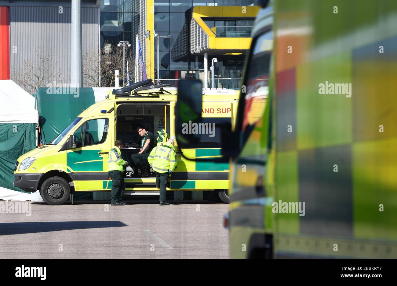 Un équipage d'ambulance attend les premiers patients du centre Excel de Londres qui est en train d'être fait dans l'hôpital temporaire NHS Nightingale pour aider à lutter contre le coronavirus. Banque D'Images