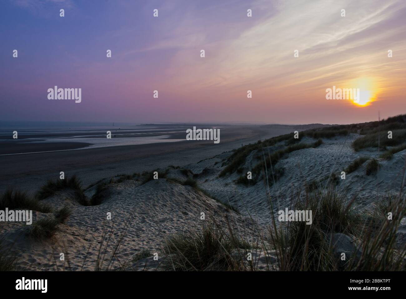 Magnifique coucher de soleil à Camber Sands avec dunes de sable et ciel rose et violet. Camber Sands, Angleterre Banque D'Images