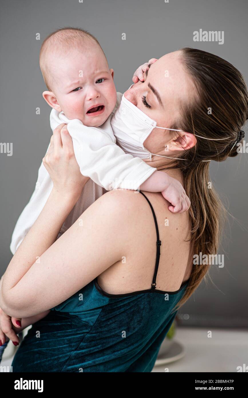Une Mere Dans Un Masque De Protection Avec Un Bebe Est Assise A La Maison En Quarantaine Pendant Le Coronovirus Et La Pandemie De Covid 19 Photo Stock Alamy