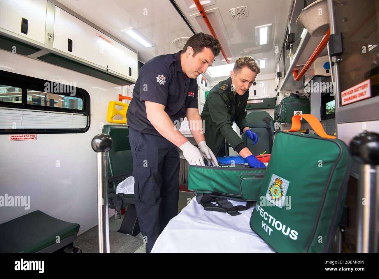 Le pompier Dominic Pearce de la London Fire Brigade (à gauche) et le paramédic Daniel Phillips du London Ambulance Service préparent une ambulance pour une utilisation au siège du London Ambulance Service alors que les pompiers participent à la formation pour se préparer à aider à un certain nombre de rôles, y compris la conduite d'ambulances, au cours de l'éclosion de coronavirus. Banque D'Images