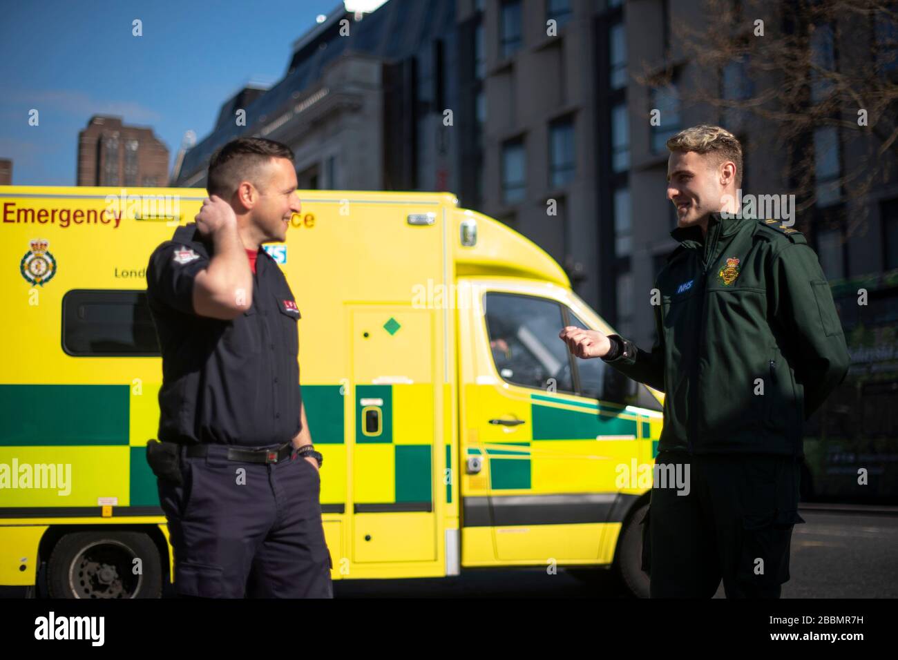 Les pompiers de la Brigade des pompiers de Londres parlent avec les paramédics du siège du Service ambulanciers de Londres lorsqu'ils se préparent à aider à un certain nombre de rôles, y compris la conduite d'ambulances, pendant l'épidémie de coronavirus. Banque D'Images