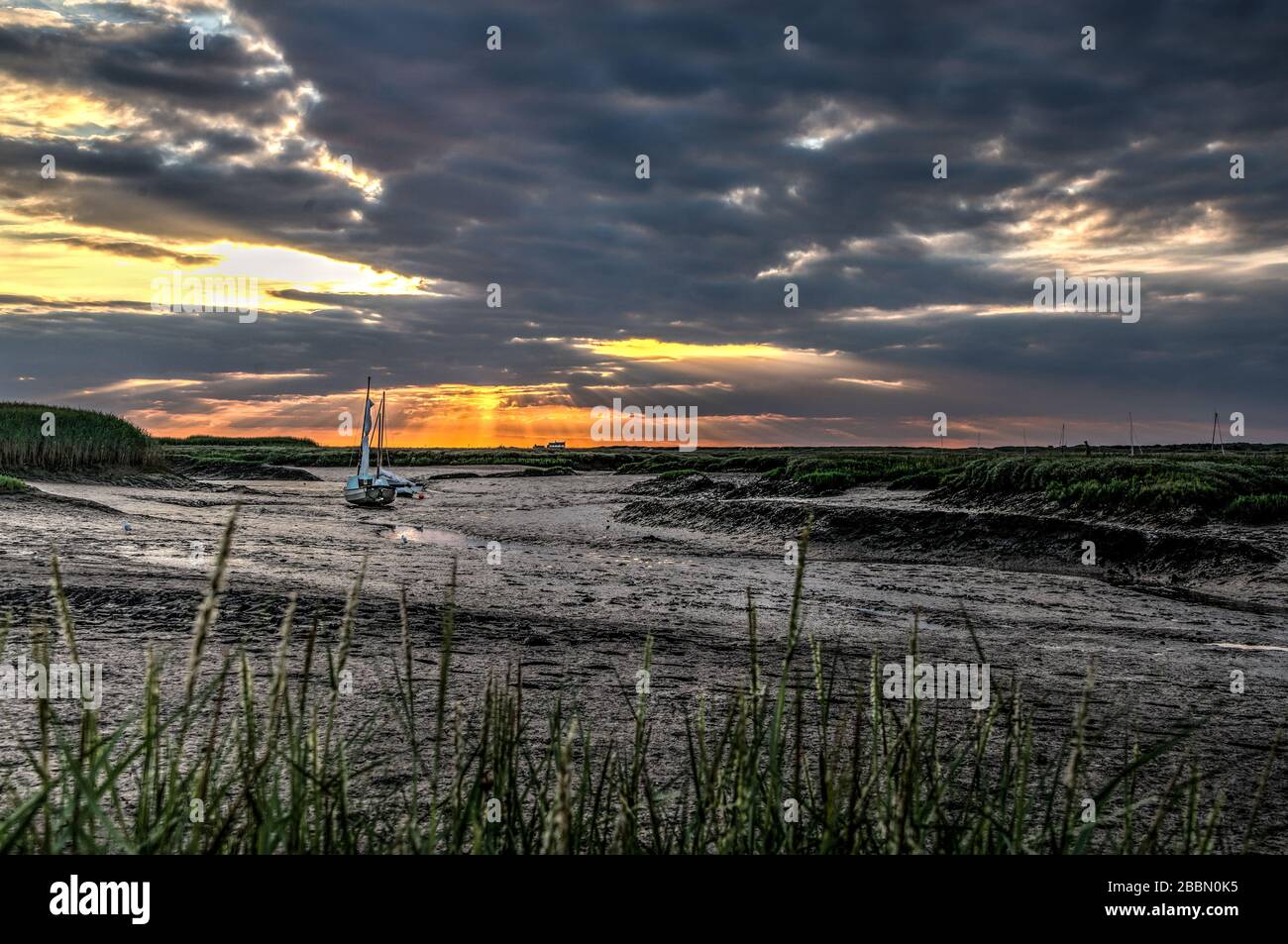 Coucher de soleil à Brancaster Straith avec bateaux de pêche, Norfolk, Angleterre Banque D'Images