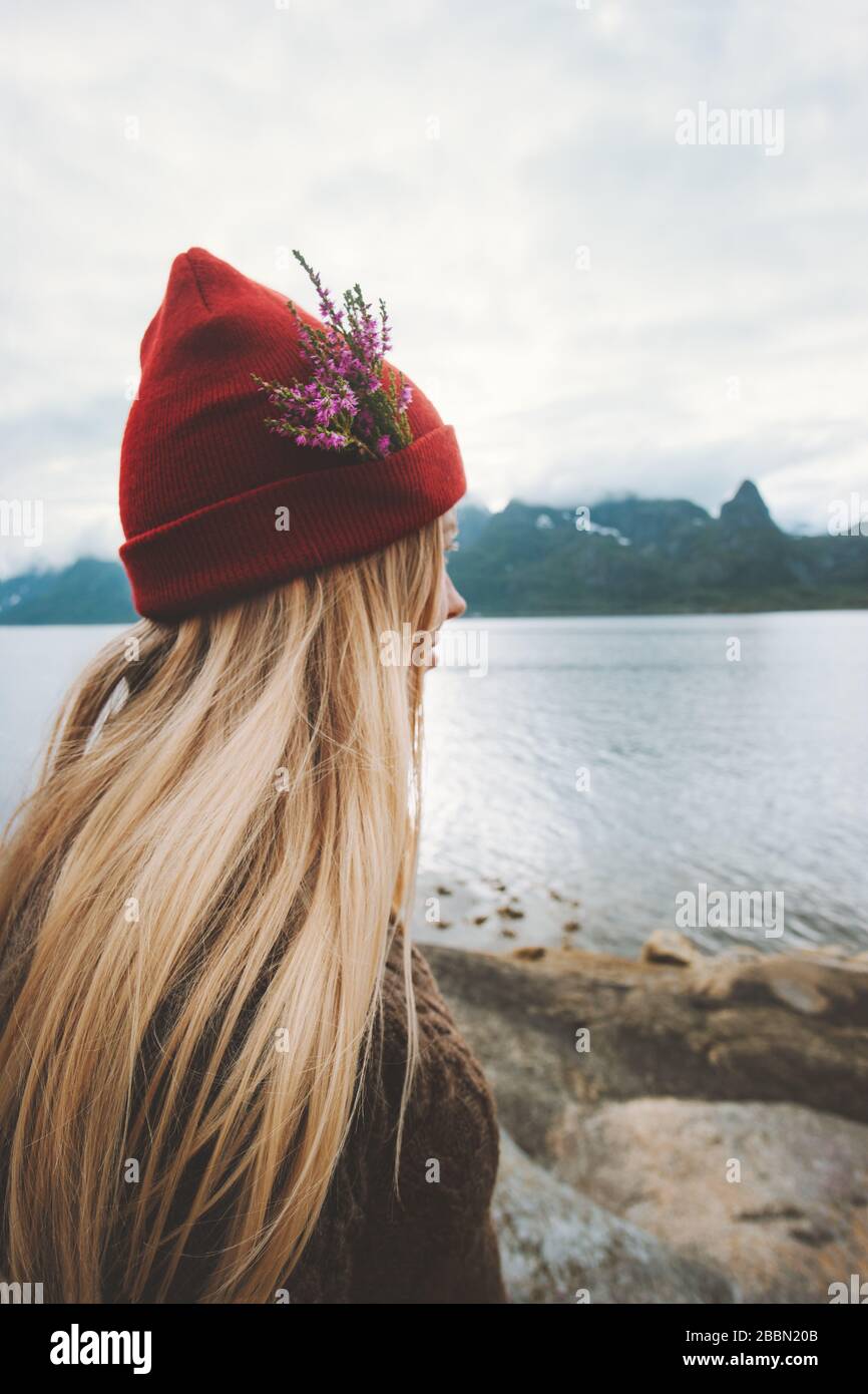 Femme portant un chapeau de bonnet rouge avec des fleurs voyageant seule  plein air vacances aventure style de vie blonde fille en profitant de la  vue en Norvège Photo Stock - Alamy