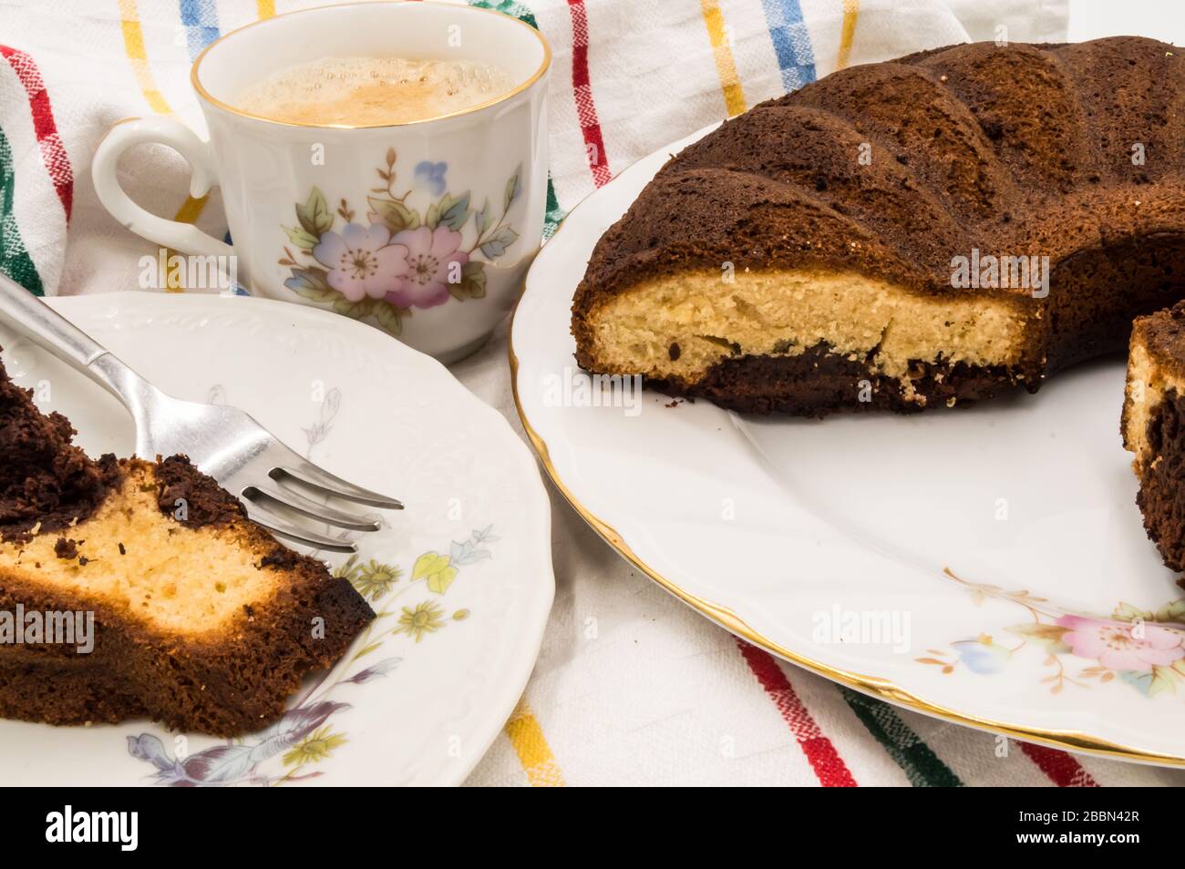 Tranche de gâteau marbré sur une assiette avec une tasse de café sur un fond de couleur Banque D'Images Tranche de gâteau marbré sur une assiette avec une tasse de café sur un fond de couleur Banque D'Images