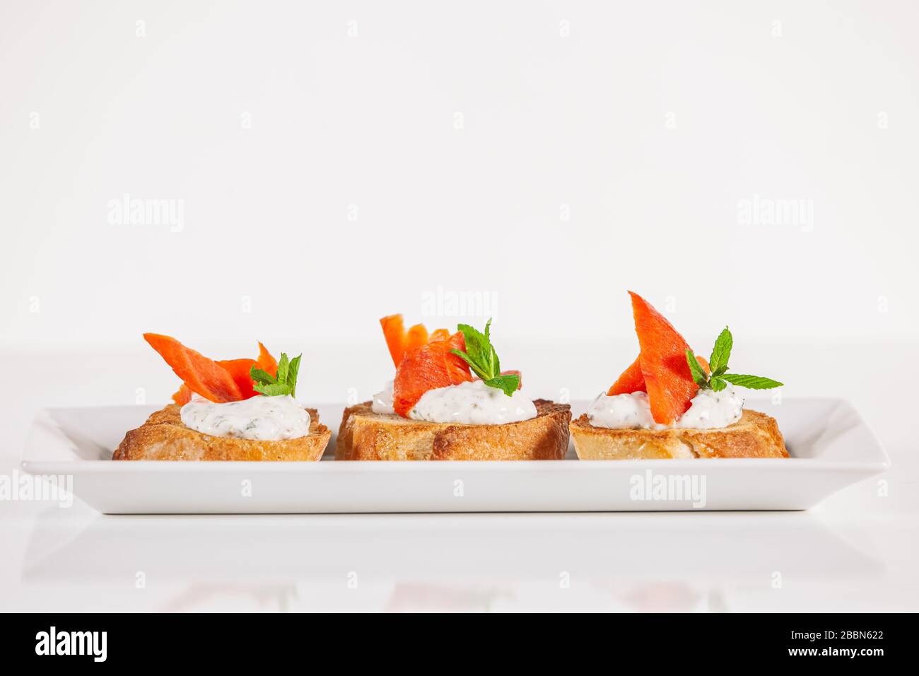 Assiette de poisson de saumon décoratif sur l'apéritif de la bruschetta Banque D'Images