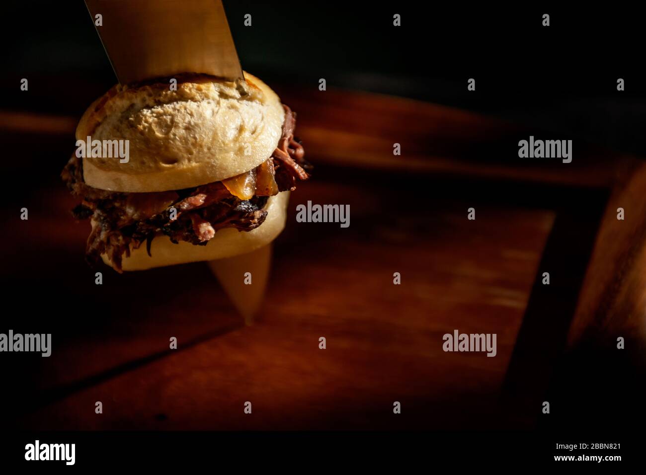 Hamburger de porc gourmand tiré avec couteau de chef Banque D'Images