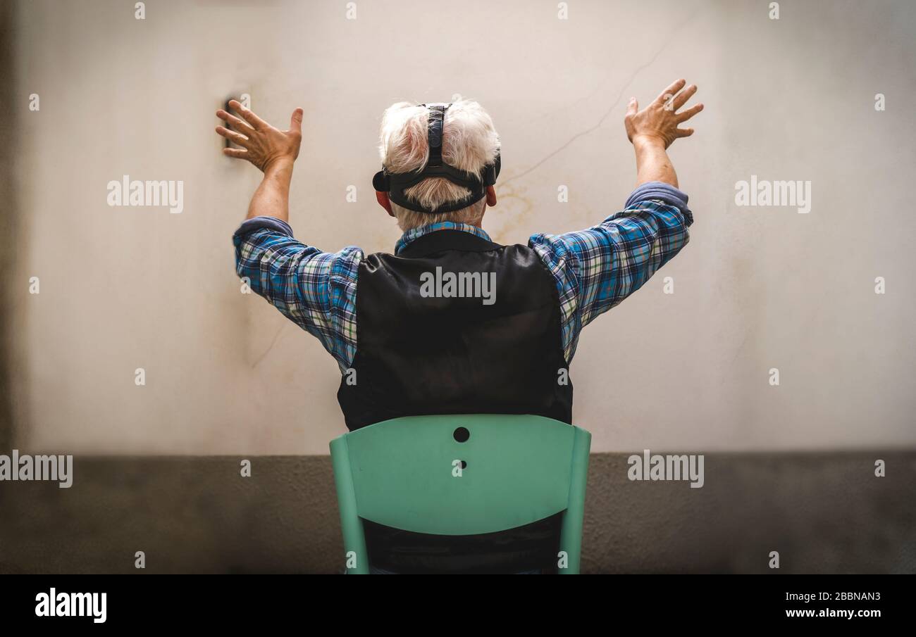 l'homme mûr regarde à travers le spectateur de la réalité virtuelle pendant la quarantaine difficile au moment du coronavirus Banque D'Images