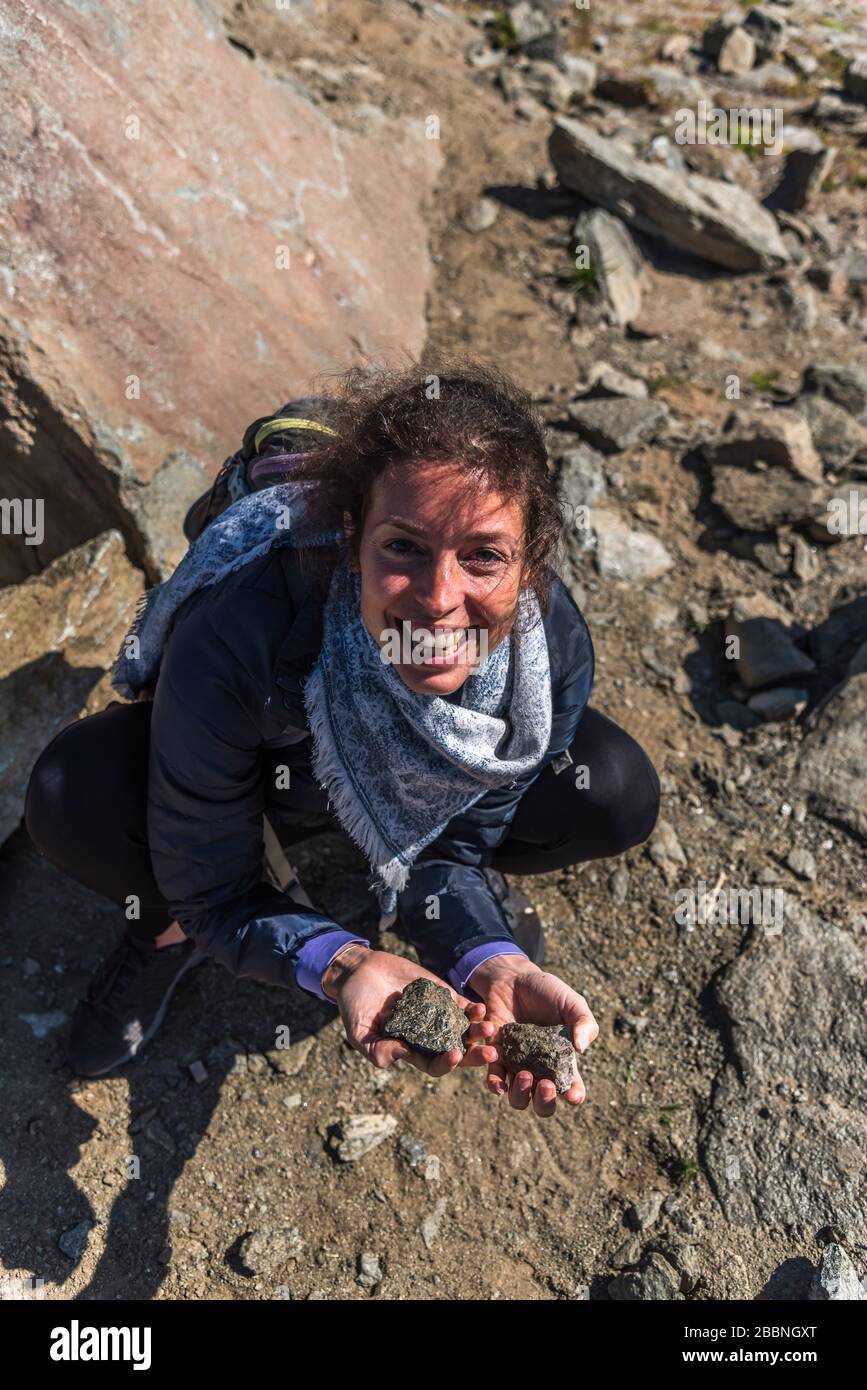 Jeune femme souriant en gardant deux pierres de quartz à haute énergie dans ses mains. Eggishorn terrasse, lieu d'énergie et de puissance Banque D'Images