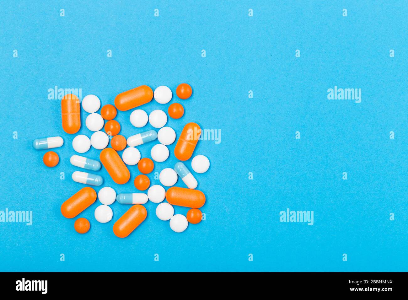 Assortiment de pilules, comprimés et capsules de médecine pharmaceutique sur fond bleu. Espace libre. Concept de santé. Banque D'Images