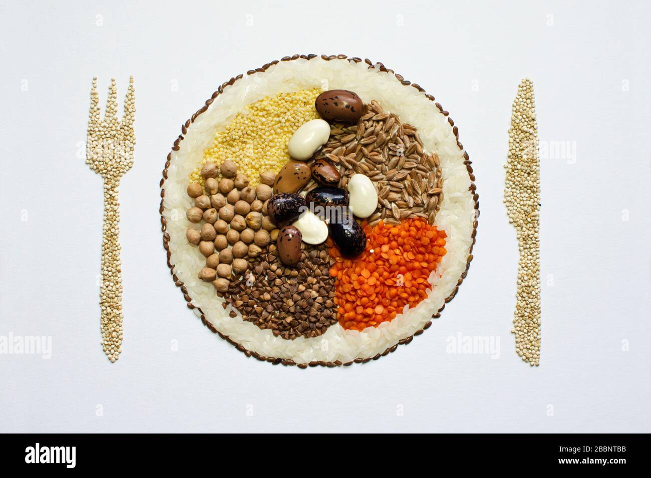 Graines art: Nourriture végétarienne saine - graines et haricots dans une assiette avec fourche et couteau en plus Banque D'Images