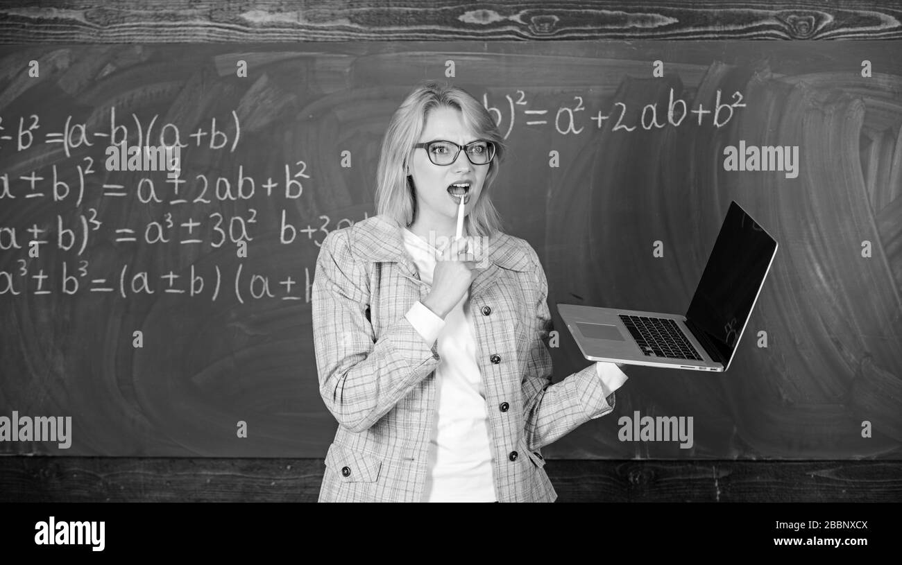 Dame intelligente smart éducateur avec ordinateur portable moderne tableau internet surf arrière-plan. Les technologies numériques concept. L'apprendre de manière simple. Enseignante portent des lunettes est titulaire d'ordinateur portable Internet surf. Banque D'Images