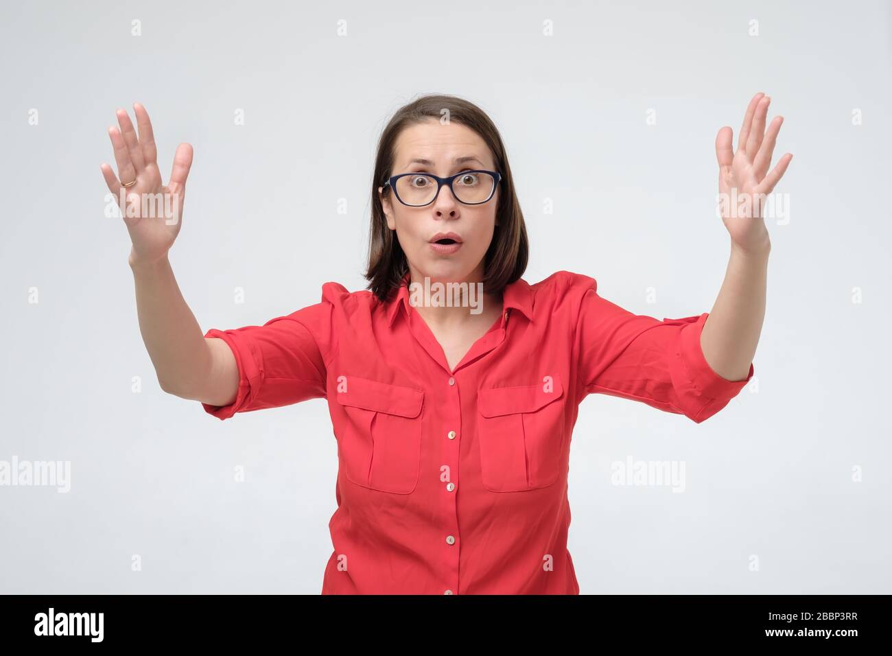 Femme surprise mûre dans des verres et des vêtements rouges faisant des  mains la taille de la grande chose. Se vanter de la taille du prix Photo  Stock - Alamy