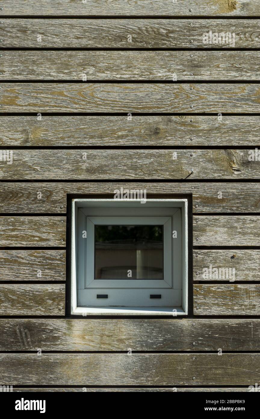 Découpe de façade avec lambris en bois et petite fenêtre carrée. Contexte Banque D'Images