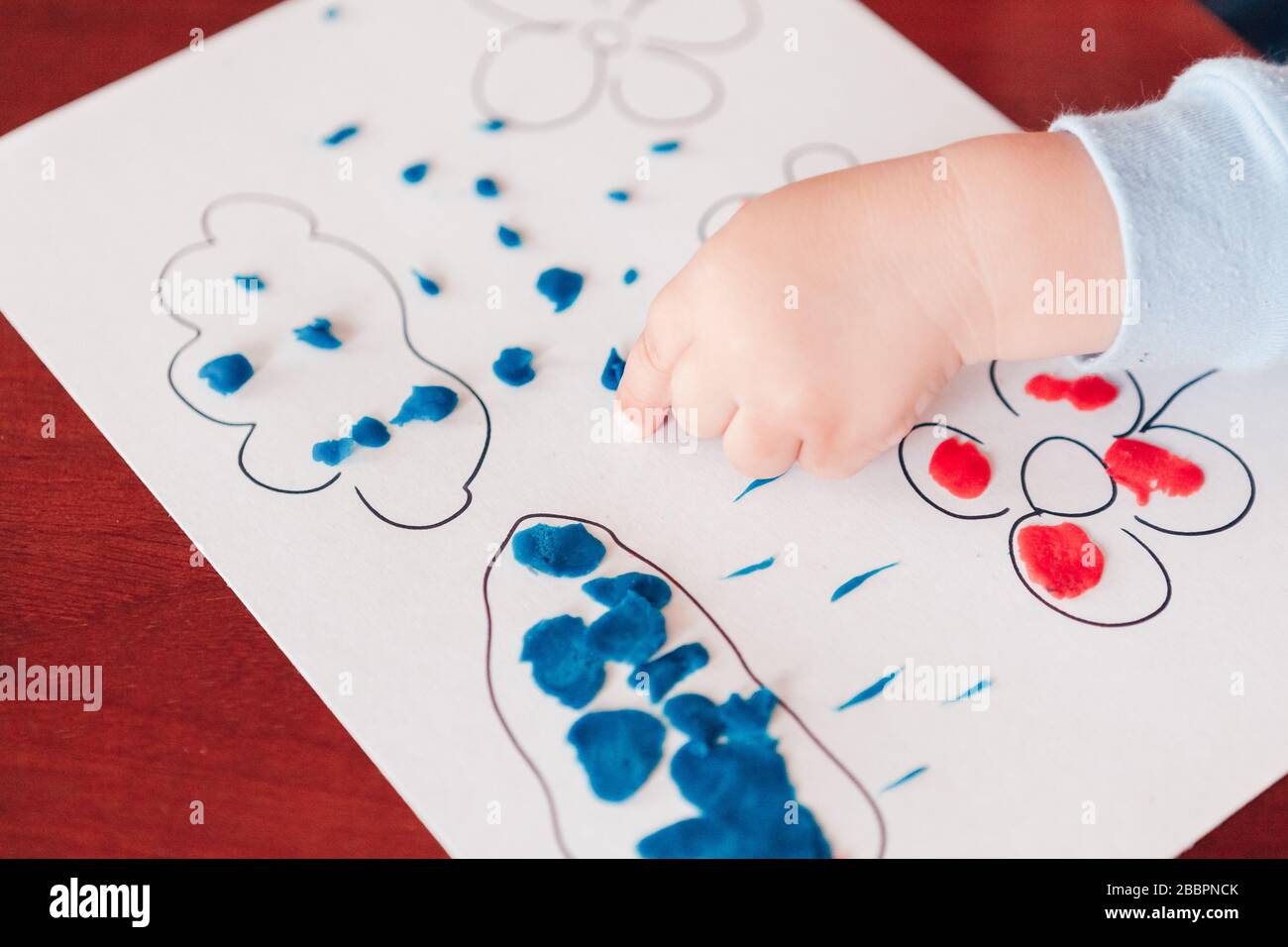 L'enfant sculpte une image de nuages avec la pluie à partir de petites pièces de plastine Banque D'Images