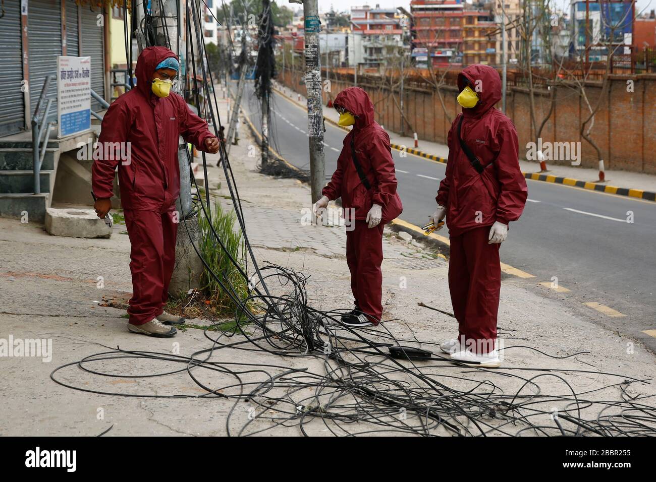 Katmandou, Népal. 1 avril 2020. Les techniciens à large bande portant des lignes Internet de correction de vêtements de protection le long d'une rue le neuvième jour du gouvernement a imposé un verrouillage sur la pandémie de COVID-19 à Katmandou, au Népal, le mercredi 01 avril 2020. Crédit: Skanda Gautam/ZUMA Wire/Alay Live News Banque D'Images