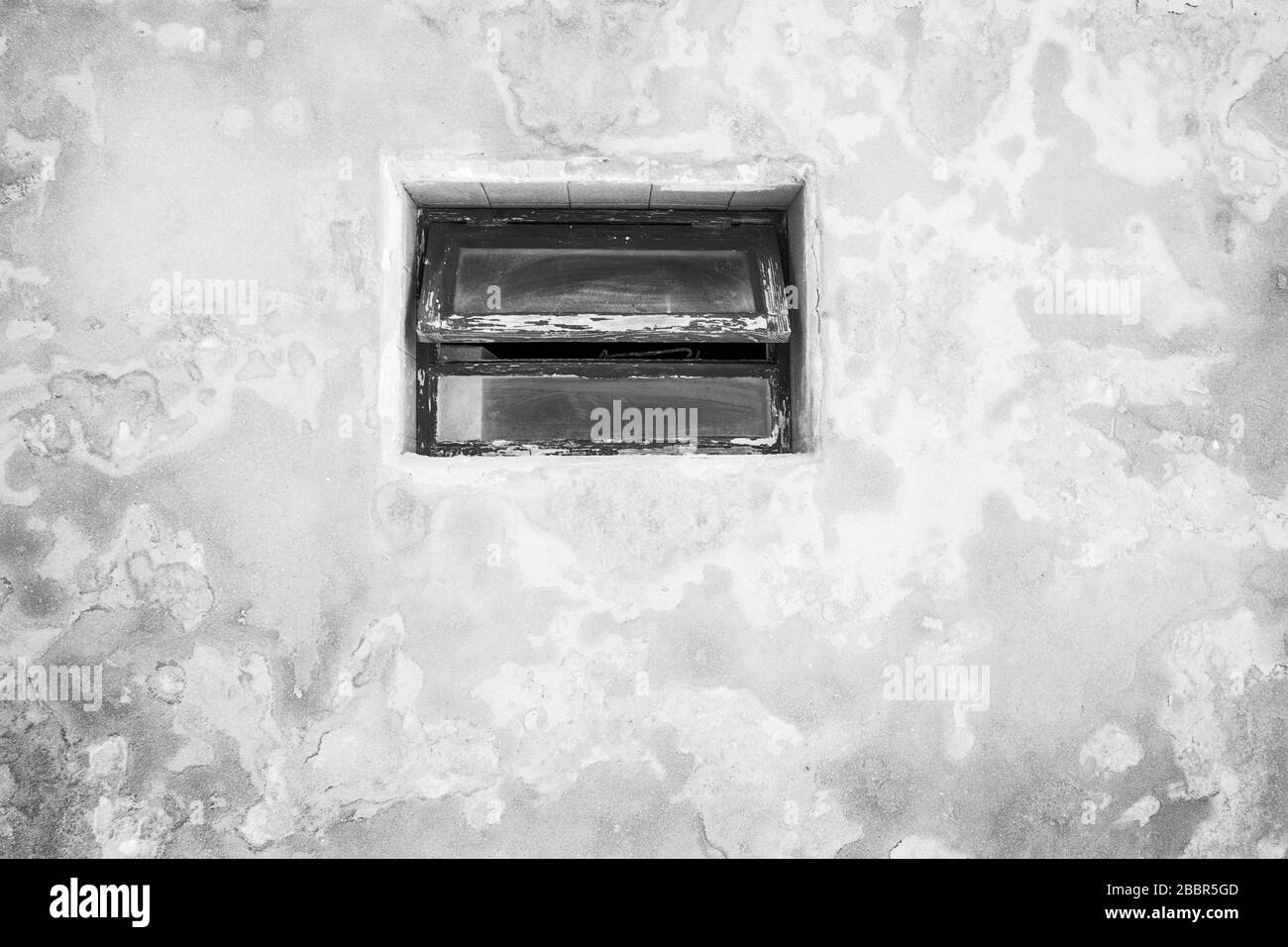 fenêtre en bois dans un vieux mur en béton texturé sur un bâtiment Banque D'Images