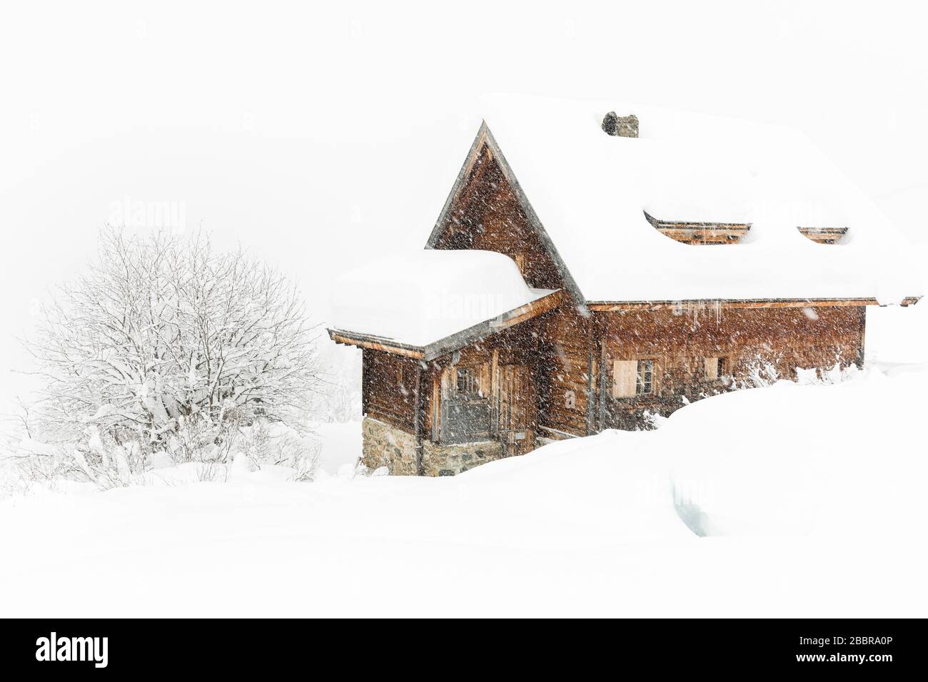 Par beau temps, chute de neige, paysage blanc extrême avec chalet en bois maison et arbre recouvert de beaucoup de neige Banque D'Images