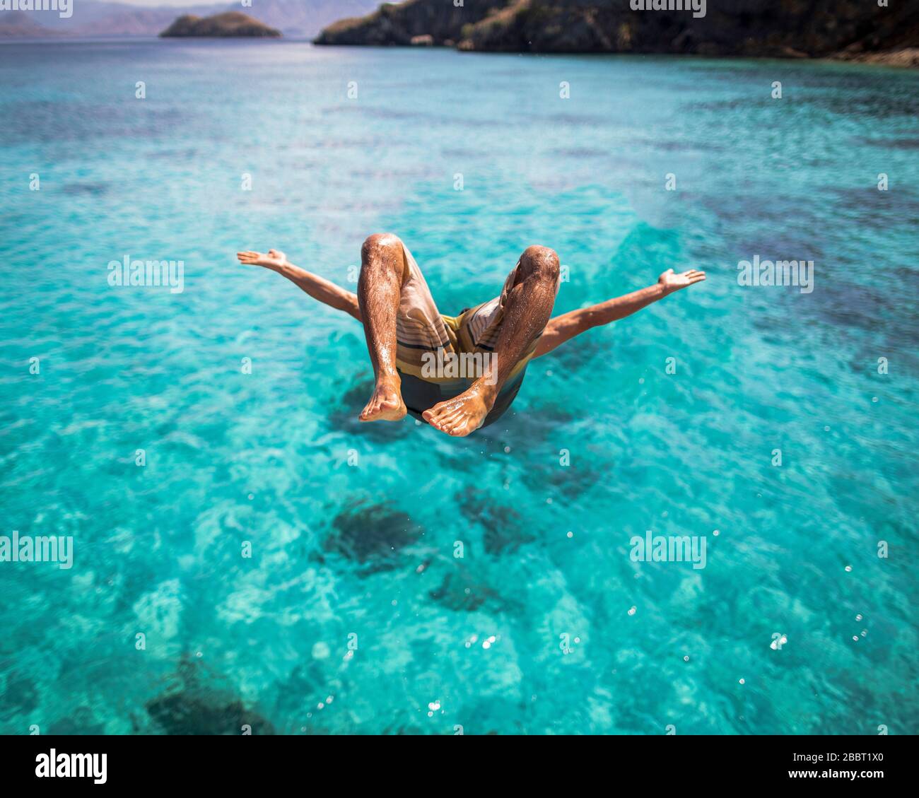 Homme sautant dans l'océan Backflip dans le parc national de Komodo Banque D'Images