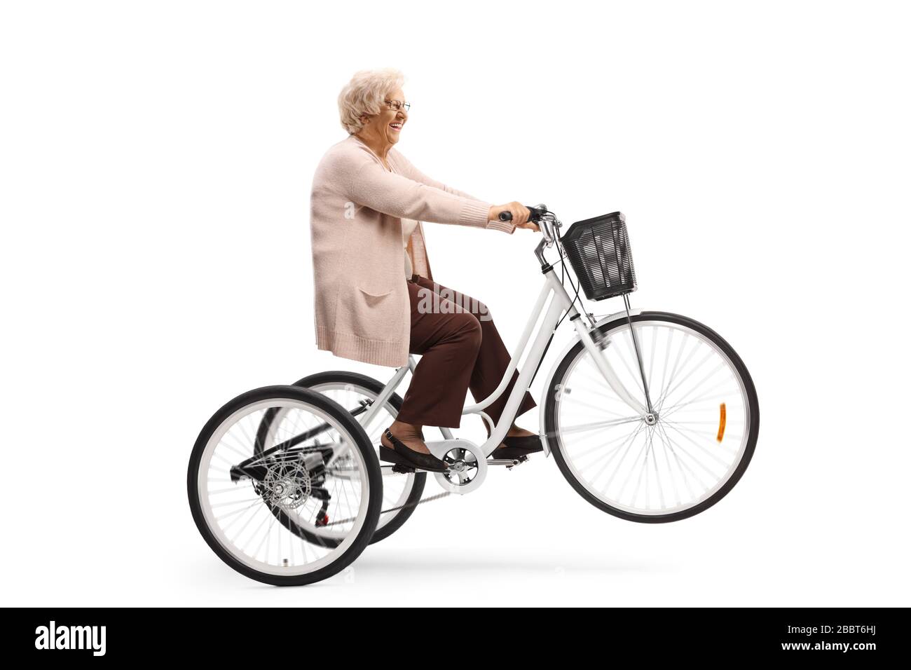Femme senior qui monte dans un tricycle et levant la roue avant isolée sur  fond blanc Photo Stock - Alamy