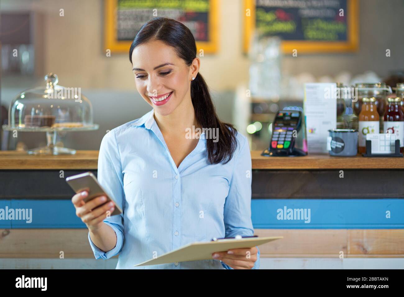 Woman working in coffee shop Banque D'Images