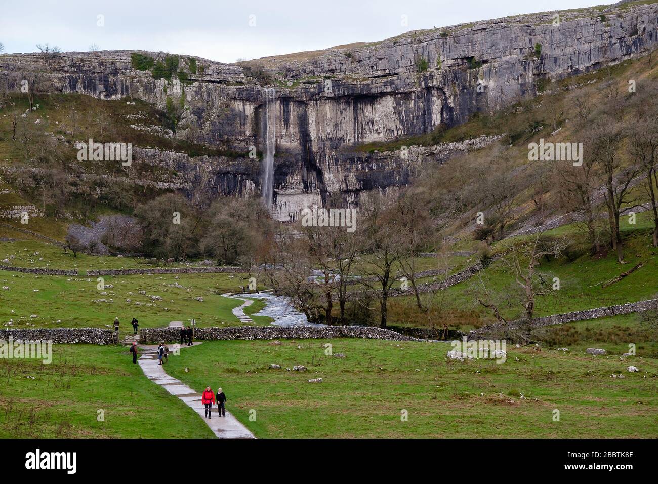 L'eau coule au-dessus de Malham Cove. Le 6 décembre 2015, après une période de forte pluie, Malham Cove devient temporairement la plus haute chute libre du Royaume-Uni. La falaise de calcaire verticale de 80 m au coeur du parc national du Yorkshire Dales a été formée au dernier âge de glace, mais l'eau n'a pas été vue se cascade de son bord dans la mémoire vive (voir « informations supplémentaires ») © Ian Wray /Alay Banque D'Images