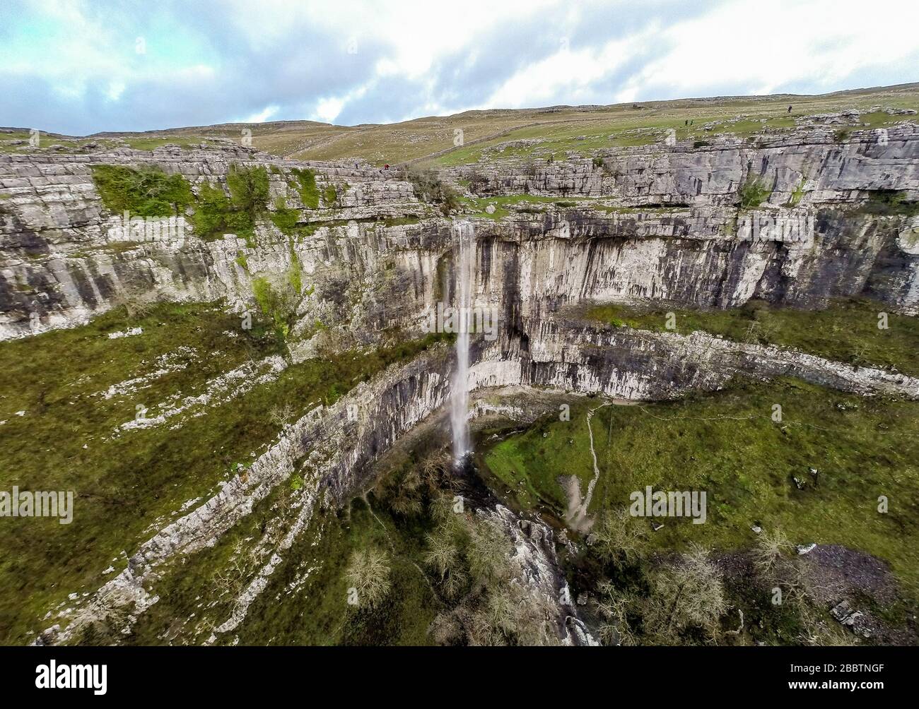 L'eau coule au-dessus de Malham Cove. Le 6 décembre 2015, après une période de forte pluie, Malham Cove devient temporairement la plus haute chute libre du Royaume-Uni. Vue aérienne sur la drone montrant la falaise de calcaire verticale de 80 m au cœur du parc national du Yorkshire Dales a été formée au dernier âge de glace, mais l'eau n'a pas été vue en cascade de son bord dans la mémoire vive (voir « informations supplémentaires ») © Ian Wray /Alay Banque D'Images